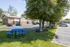 Charming suburban apartment complex with lush green lawns, mature trees, and convenient parking.