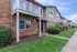 Charming brick apartment building with private balconies and well-manicured landscaping, offering a welcoming community atmosphere.