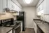 Modern kitchen with sleek black appliances, stylish white cabinets, and sophisticated countertops, perfect for culinary creativity.