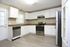 Modern kitchen with sleek stainless steel appliances, elegant granite countertops, and bright white cabinetry offering ample storage space.