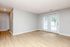 Bright and spacious living room with elegant wood flooring and large sliding glass doors leading to outdoor views.