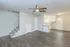 Modern open-concept living area with elegant wood flooring, bright kitchen, and cozy staircase.
