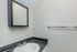 Modern bathroom with a sleek black countertop, elegant chrome faucet, and a contemporary wall-mounted mirror.