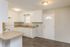 Bright and inviting kitchen featuring white cabinetry, sleek countertops, and modern lighting, offering a welcoming culinary space.