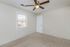 Bright, cozy room with a modern ceiling fan, neutral walls, and a window bringing in natural light, offering a warm and inviting atmosphere.