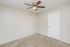 Bright and airy room with fresh carpeting and a modern ceiling fan, perfect for relaxation.
