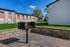 Charming apartment complex with outdoor grilling area amidst lush green landscaping under a bright blue sky.