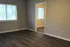 Bright, open room with sleek hardwood floors and large windows offering abundant natural light.