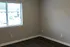 Bright and inviting room with stylish dark flooring and a large window letting in natural light, perfect for a cozy retreat.