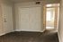 Inviting entryway with modern double doors, plush carpeting, and bright hallway leading to a cozy room.