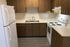 Modern kitchen featuring sleek wood cabinets, double sink, and a white electric stove with spacious countertops.