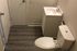 Modern bathroom with sleek fixtures, wood-style flooring, and crisp white vanity, offering a contemporary and clean design.