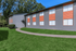 Charming apartment building with modern gray exterior and vibrant orange accents, surrounded by lush green lawn.