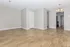 Bright and spacious living area featuring elegant hardwood floors, neutral walls, and stylish overhead lighting, perfect for modern living.