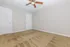 Bright and airy room with plush carpet flooring and modern ceiling fan, perfect for a cozy bedroom or home office.