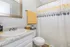 Bright and modern bathroom featuring a sleek granite countertop, elegant mirror, and vibrant yellow accents.