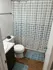 Charming modern bathroom with sleek white fixtures, elegant marble countertop, and stylish polka dot shower curtain.