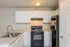 Modern kitchen boasting sleek black appliances, elegant white cabinetry, and sparkling marble countertops.