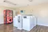 Bright laundry room featuring modern washers, a convenient vending machine, and a change station for easy laundry days.