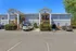 Charming two-story apartment building with attractive exterior, ample parking, and lush greenery.