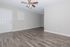 Bright and welcoming living space featuring elegant wood flooring and a stylish ceiling fan.