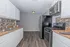 Modern kitchen with sleek black appliances, minimalist white cabinets, and elegant tile backsplash.
