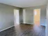 Inviting apartment interior with elegant wood flooring and freshly painted walls, leading to two bright doorways.