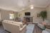 Inviting living room with vaulted ceilings, featuring a stone fireplace, elegant furnishings, and abundant natural light.