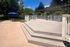 Inviting outdoor patio with wooden deck, sun loungers, and shaded seating area nestled among lush greenery.