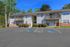 Charming two-story apartment complex with private balconies, surrounded by lush greenery and featuring accessible parking spaces.