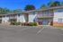 Charming apartment building with private balconies, surrounded by lush greenery and ample parking space.