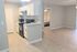 Modern open-concept apartment featuring a sleek kitchen with white cabinetry, spacious living area, and a cozy bedroom.
