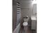 Modern bathroom featuring sleek fixtures, elegant striped shower curtain, and crisp white vanity, offering a serene retreat.