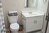 Modern bathroom featuring a chic vanity with a large mirror, sleek fixtures, and soft towel accents for a touch of luxury.