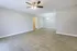 Bright and open living area with elegant wood flooring and modern ceiling fan, ideal for stylish apartment living.