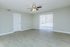 Bright and airy room with elegant wooden flooring, large windows, and a ceiling fan, perfect for a modern and cozy living space.