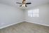 Bright and airy room with elegant wooden floors and a modern ceiling fan, perfect for relaxation.