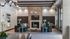Elegant open-concept living space featuring modern teal couches, a stylish fireplace, and chic light fixtures against a backdrop of neutral tones and soft lighting.