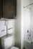 Modern bathroom featuring sleek cabinetry, a chic shower curtain, and towels with motivational words for a stylish touch.