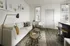 Chic modern living room with a cozy sofa, stylish decor, and a breakfast bar with seating, offering a bright and welcoming space.