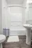 Bright and modern bathroom featuring elegant white fixtures, a clean shower with decorative curtain, and stylish wood flooring.