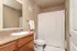 Bright and modern bathroom featuring a sleek countertop, elegant sink, and stylish shower with a patterned curtain.