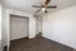 Bright and airy bedroom with modern wood flooring, ceiling fan, and spacious closet, perfect for comfortable living.