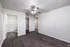 Bright and inviting room with sleek wood flooring, ceiling fan, and access to a modern en-suite bathroom.