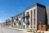 Modern apartment complex with sleek balconies and stylish brickwork, under a clear blue sky.