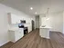 Modern kitchen with sleek white cabinetry, stainless steel appliances, and elegant pendant lighting over a spacious island, featuring stylish wood flooring.