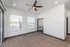 Bright and modern living space with elegant wood flooring, large windows, and a sleek ceiling fan.