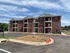 Charming brick apartment building with spacious balconies and ample parking, ideal for modern living.