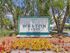 Inviting Weston Ranch entrance sign surrounded by lush greenery and vibrant flowers under a sunny sky.