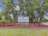 Inviting Weston Ranch entrance sign surrounded by lush greenery and vibrant flowers, offering a serene and welcoming atmosphere.